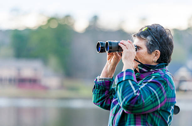 istock Older Woman Birdwatching by the Lake 513673004