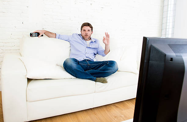 istock young happy man watching television relaxed on sofa 513680266