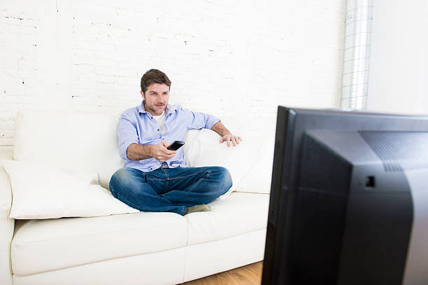 istock young happy man watching television relaxed on sofa 513680420