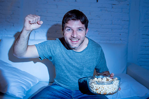 istock young happy man watching television sport match cheering victory 513681110