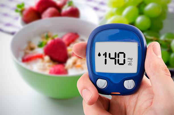 Diabetes doing glucose level test. Fruits in background stock photo