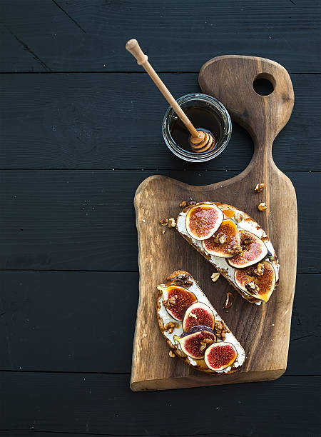 istock Sandwiches with ricotta, fresh figs, walnuts and honey on rustic 513688598