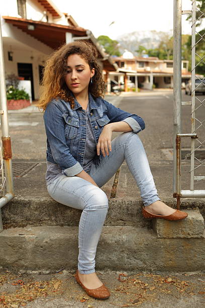 istock Young Urban Girl Poses Sitting on Sidewalk 513690878