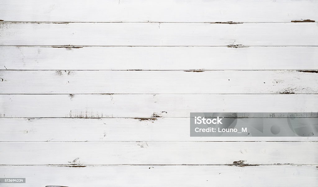 Distressed white wood texture background Distressed white wood texture background viewed from above. The wooden planks are stacked horizontally and have a worn look. This surface would be great as design element for a wall, floor, table etc. White Color Stock Photo