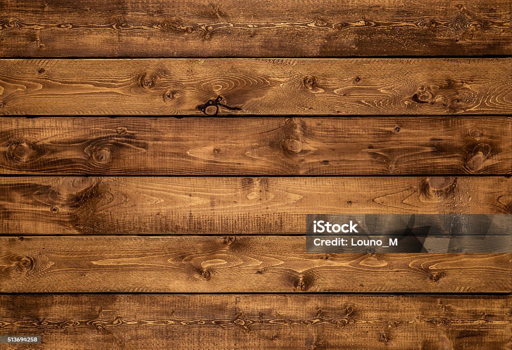 Medium golden brown wood texture background Medium brown wood texture background viewed from above. The wooden planks are stacked horizontally and have a worn look. This surface would be great as design element for a wall, floor, table etc. Wood - Material Stock Photo