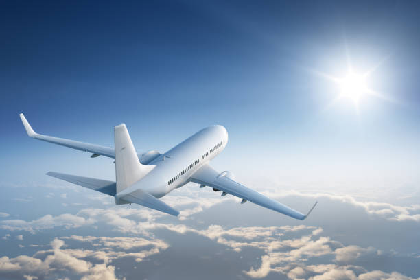 Flying towards the sun Airplaine flies above the calm cloudscape towards the sun. planes flying overhead stock pictures, royalty-free photos & images