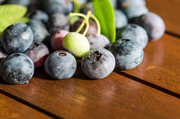istock pile of blueberries lying on wooden table 513703323