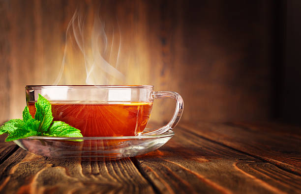 istock Cup of tea and mint on a wooden background 513704499