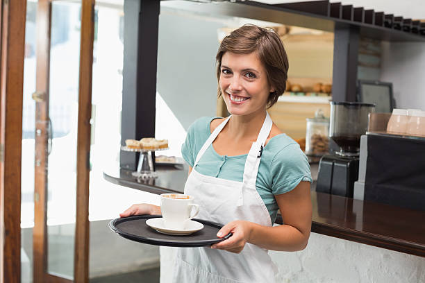 istock Pretty barista smiling at camera holding tray 513704613
