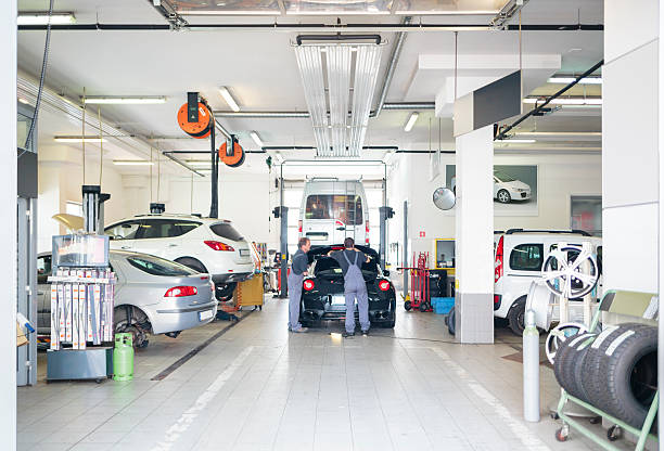 autofficina con auto servita da meccanica - car examining mechanic auto mechanic foto e immagini stock