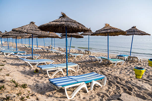 istock Sun umbrella on an empty beach and sea water horizon. 513706489