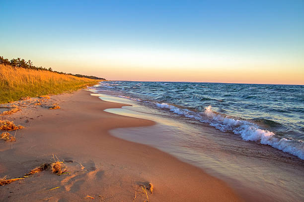Beach Background At Sunset Gorgeous sandy beach stretches to the horizon. lake michigan photos stock pictures, royalty-free photos & images