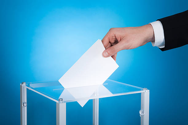 istock Businessman Putting Paper In Election Box 513708397