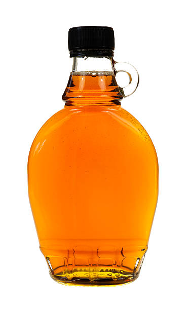 Bottle of maple syrup A full bottle of real maple syrup on a white background. maple syrup stock pictures, royalty-free photos & images