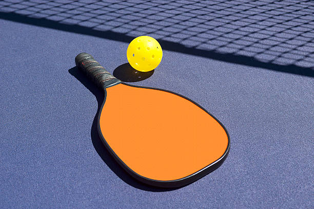 istock Pickleball - Orange Paddle Yellow Ball Net Shadow 513726615