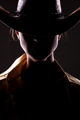 unknown woman with a cowboy hat and face in shadow