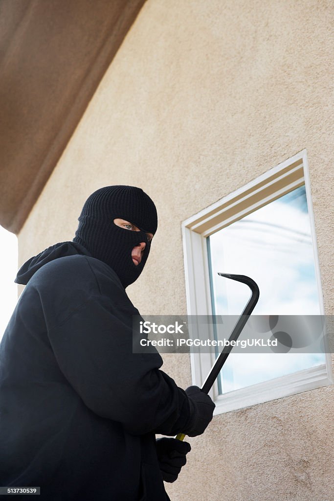 Burglar breaking into home Burglar using crowbar to get into house 30-39 Years Stock Photo