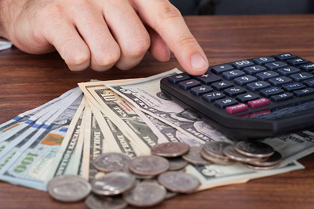 istock Businessman Using Calculator With Coins And Banknotes On Desk 513731083