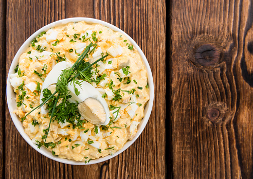 Bowl with Egg Salad on dark wooden background