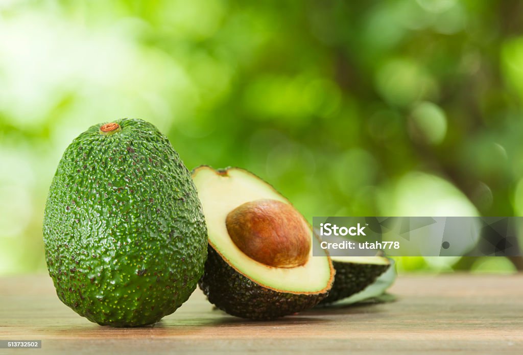 avocado Avocado and avocado pieces on a wooden floor and has a background of nature; Selected focus Avocado Stock Photo