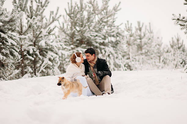 istock couple with a dog in winter forest 513740242
