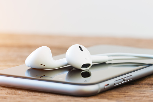 Bangkok, Thailand - Dec 9, 2015 : iphone 6 and earpods on wood table, iphone 6 is developed by apple Inc.