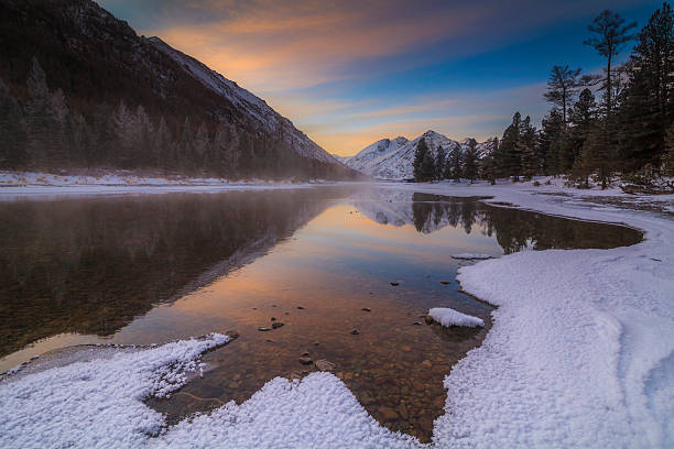 красивый зимний пейзаж с горами и закат небо. - winter stream river snowing стоковые фото и изображения