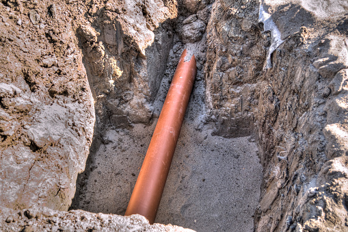 Tone mapped HDR image of a deep trench dug in the ground for a large plastic pipeline.