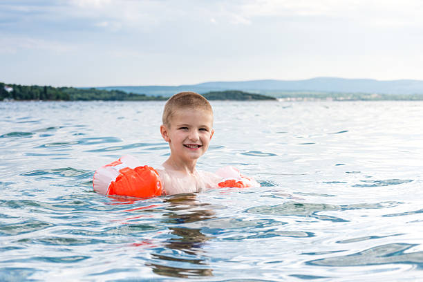 istock Boy swimming with water wings 513750162