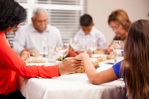 familia tiene las manos y prays antes de comer vacaciones la cena. - family thanksgiving dinner praying fotografías e imágenes de stock