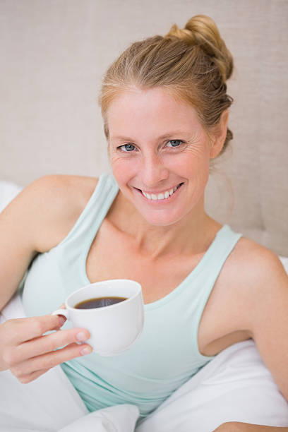 istock Happy blonde drinking coffee in bed 513751403