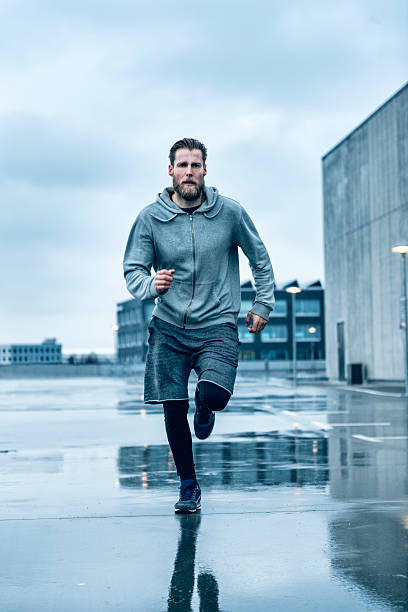 istock Fast male runner runs outside in the rain 513752022