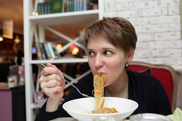 istock Hungry woman eating noodles 513752044