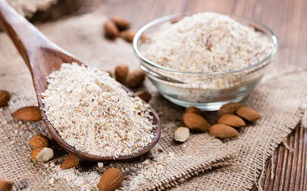 Portion of fresh grated Almonds on wooden background