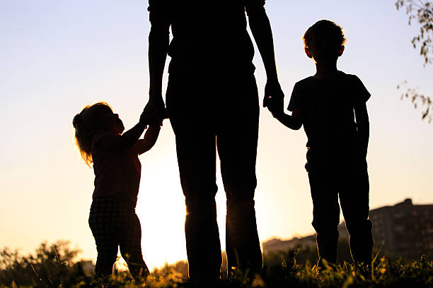 istock mother and two kids walking on sunset 513752796