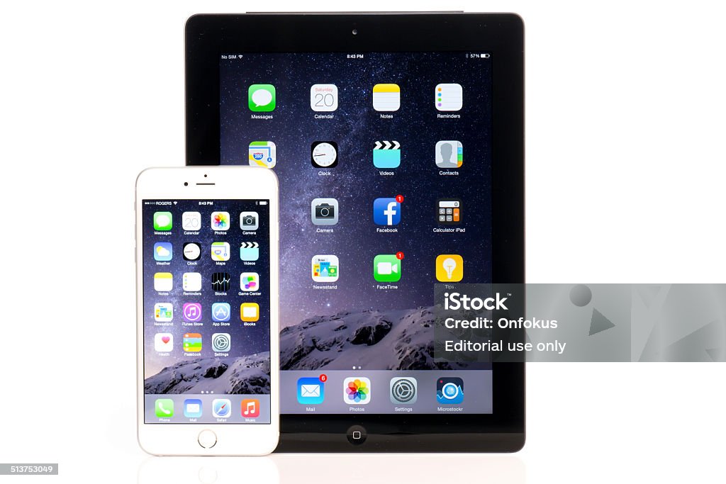 iPhone 6 Plus And iPad Comparison Isolated on White Background Montreal, Сanada - September 20, 2014: Apple iPhone 6 Plus in front of an Apple iPad tablet. Both devices are showing the homepage with the same default wallpaper and are isolated on white on a reflective surface. Apple Computers Stock Photo