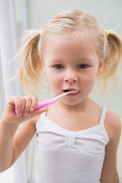 istock Cute girl brushing her teeth 513753213