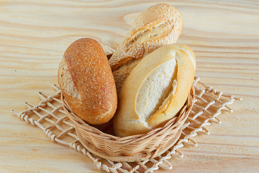 Brazilian french bread integral, mini baguette, with sesame in wicker basket. Selective focus