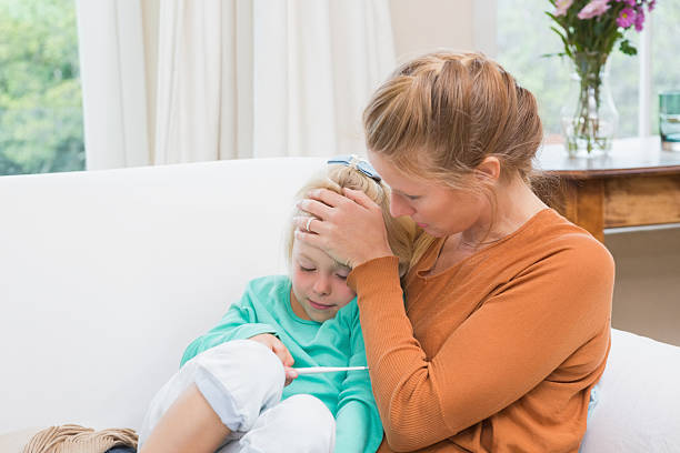 istock Mother taking the temperature of sick daughter 513756943