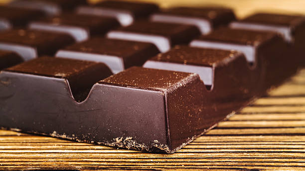istock Black chocolate bar on wooden table, close-up 513759780