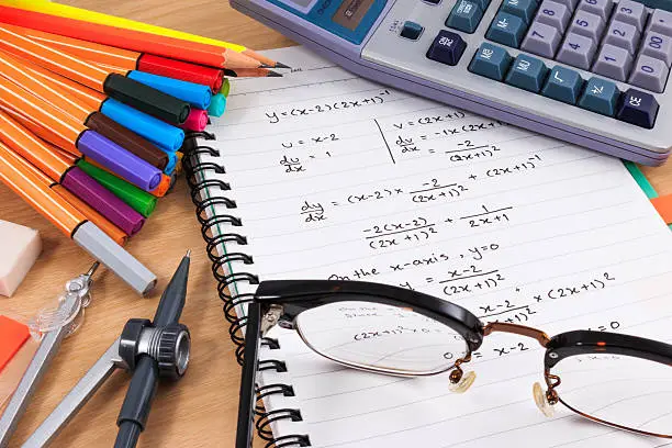 Photo of Math Equation Notebooks and office Stationery on wood table.