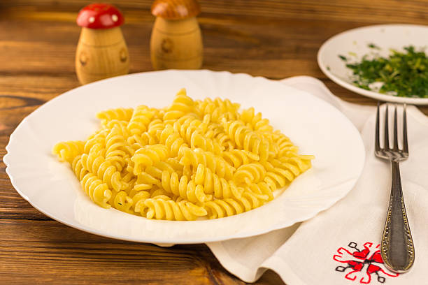 istock Italian pasta fusilli in plate on wooden table 513762070
