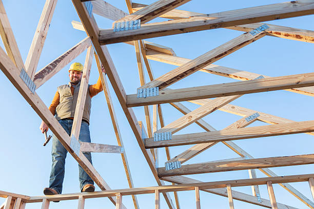 istock Construction worker with hammer on roof of house frame 513762378