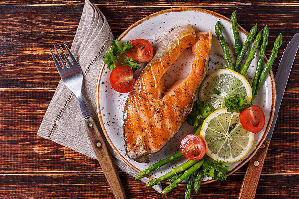 istock Grilled salmon steak served with asparagus, tomato and lemon. 513763566