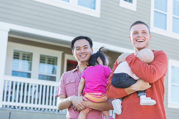 istock Two fathers holding young children standing outdoors 513763778