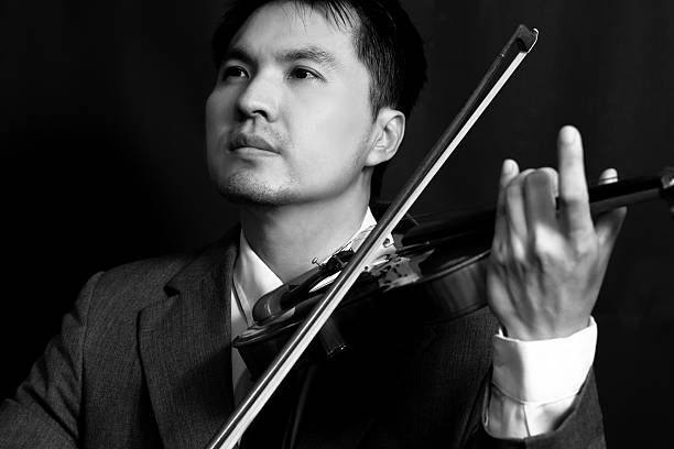 istock asian musician plays violin on dark background 513782157