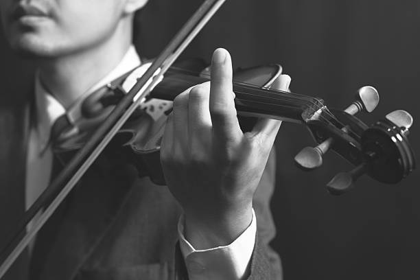 istock asian musician plays violin on dark background 513782165