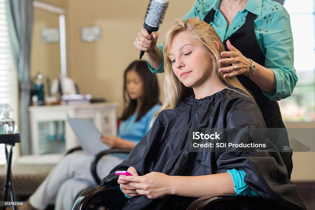 Salon Customer Using Smart Phone While Stylist Cuts Hair Stock Photo -  Download Image Now - iStock