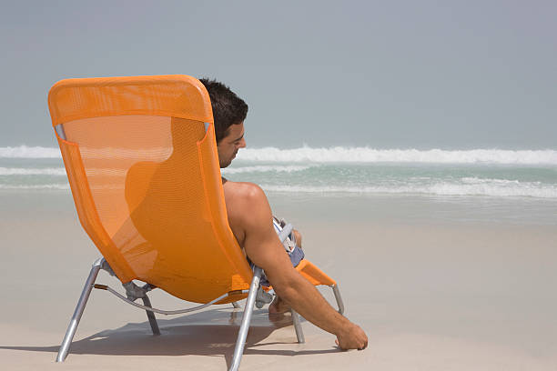 istock Rear View Of Man On Deckchair At Beach 513782393
