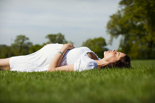 istock Pregnant Woman Lying On Grass 513782405